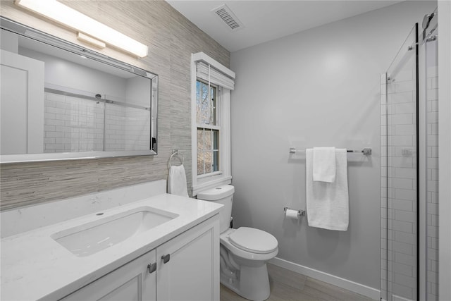 bathroom with vanity, toilet, and a shower with door