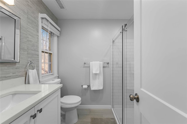 bathroom with vanity, toilet, and an enclosed shower