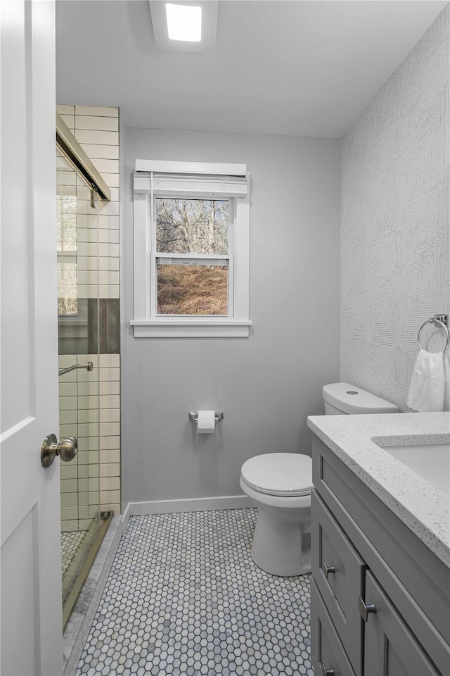 bathroom featuring vanity, toilet, and a shower with door