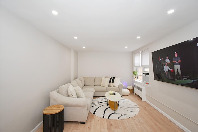 living room with radiator heating unit and light hardwood / wood-style flooring