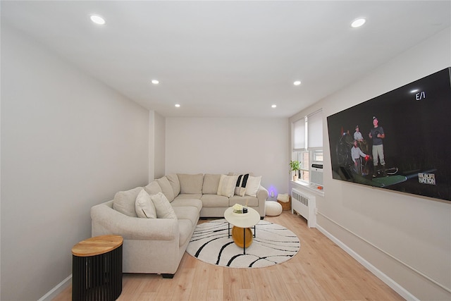 living room featuring radiator heating unit and light wood-type flooring