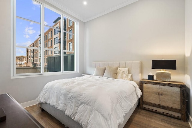 bedroom with dark hardwood / wood-style flooring and crown molding