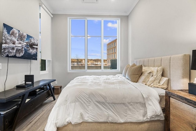 bedroom with crown molding and hardwood / wood-style flooring