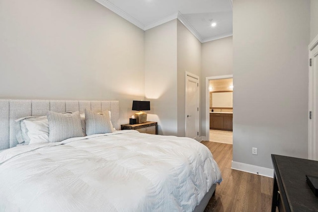 bedroom featuring ensuite bathroom, crown molding, and hardwood / wood-style floors