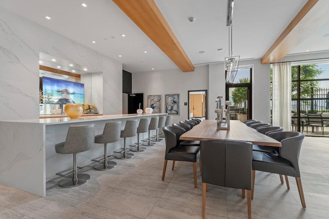 dining space featuring tile walls and beamed ceiling