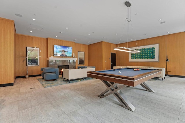 game room featuring a fireplace, wooden walls, and billiards