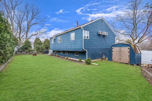 rear view of house with a wall mounted AC, a yard, and a shed