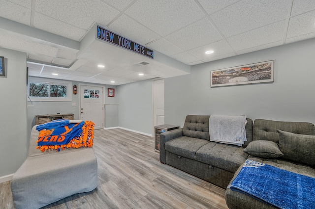 living room with a paneled ceiling and wood-type flooring