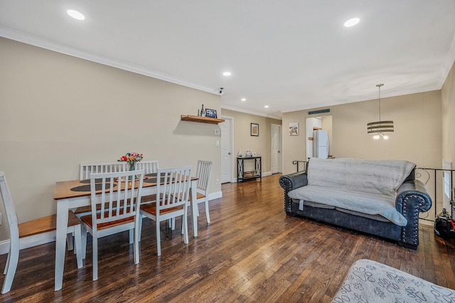 living room with dark wood-type flooring, crown molding, and a notable chandelier