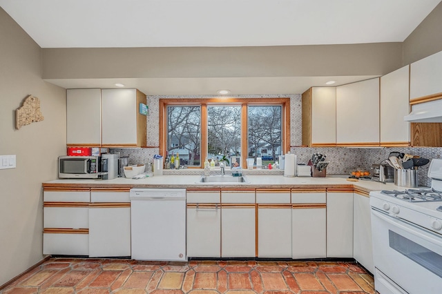 kitchen featuring white cabinets, white appliances, tasteful backsplash, and sink