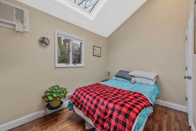 bedroom featuring lofted ceiling with skylight, dark wood-type flooring, and a wall mounted air conditioner