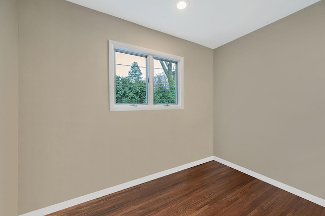 unfurnished room with dark hardwood / wood-style flooring