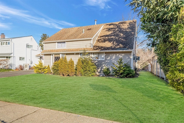 view of front of home with a front lawn and ac unit