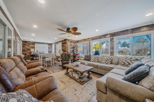 living room featuring ceiling fan, ornamental molding, and light hardwood / wood-style floors