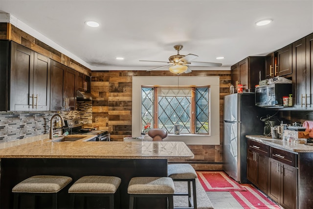 kitchen featuring a breakfast bar, kitchen peninsula, sink, and stainless steel appliances