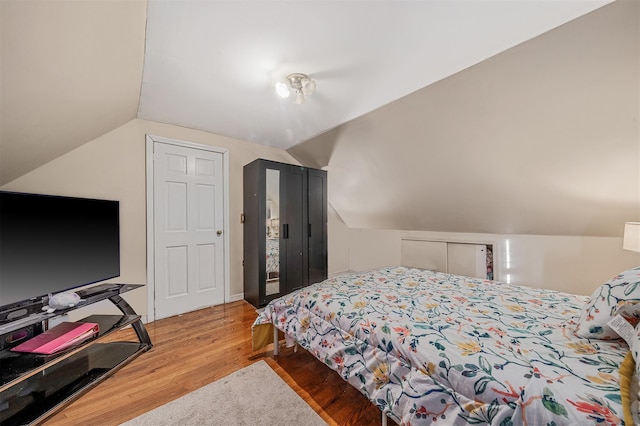 bedroom with lofted ceiling and hardwood / wood-style floors