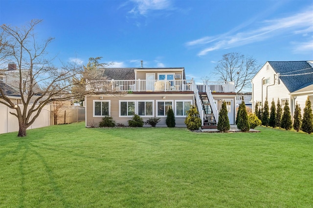 rear view of property with a wooden deck and a yard