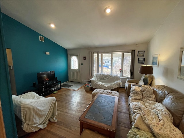 living room featuring vaulted ceiling, wood-type flooring, and a baseboard radiator