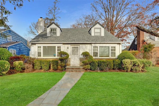 cape cod house featuring a front yard