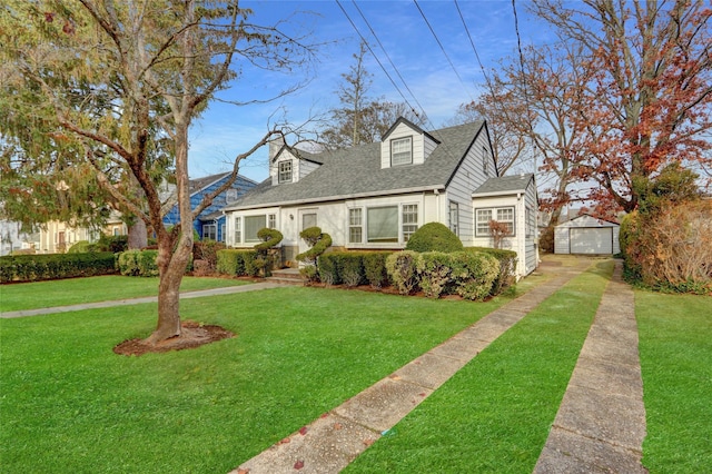 cape cod home featuring a garage, an outdoor structure, and a front lawn