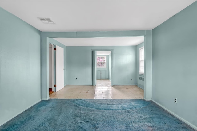 empty room with light carpet and radiator heating unit