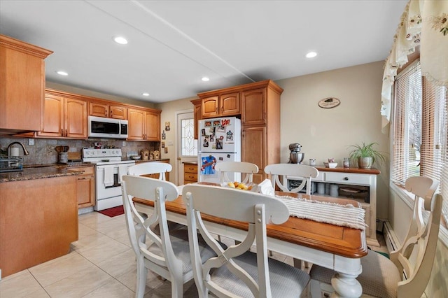 kitchen with decorative backsplash, sink, light tile patterned floors, and white appliances