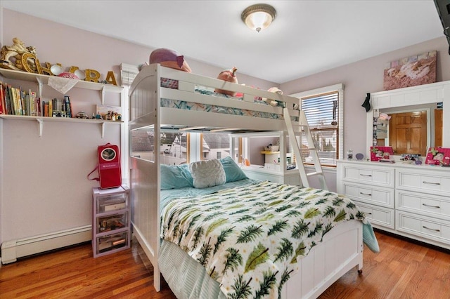 bedroom featuring baseboard heating and wood-type flooring