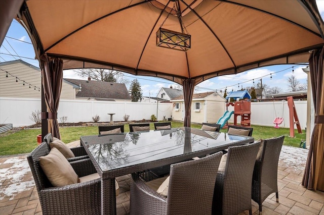 view of patio with a gazebo, a storage shed, and a playground