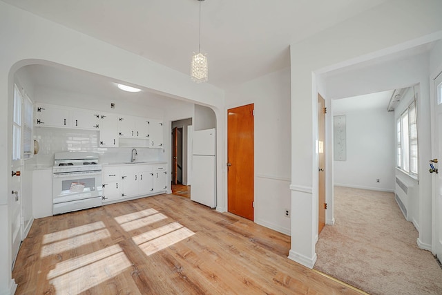 kitchen with light colored carpet, backsplash, pendant lighting, sink, and white appliances