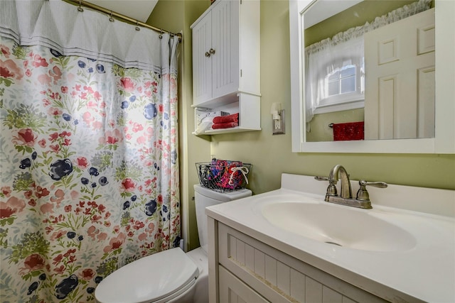 bathroom featuring toilet, vanity, and walk in shower