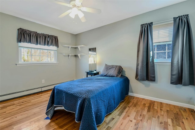 bedroom featuring a baseboard radiator, ceiling fan, and light hardwood / wood-style flooring