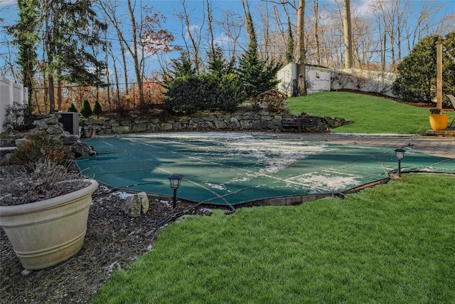 view of pool featuring a lawn