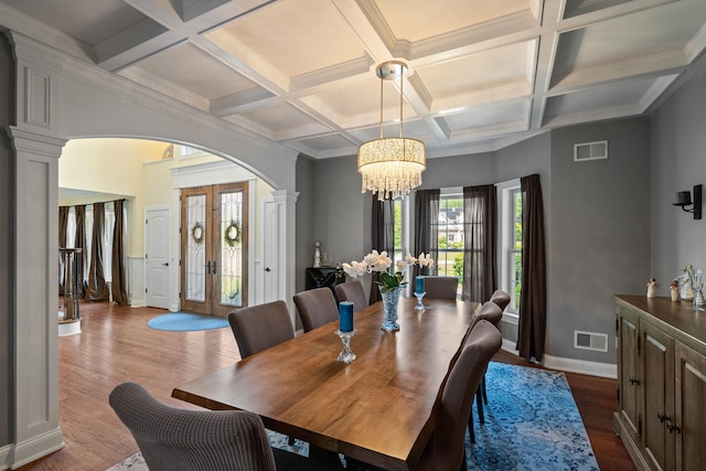 dining space with ornate columns, french doors, a chandelier, hardwood / wood-style flooring, and coffered ceiling