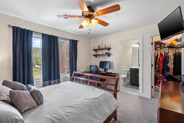 bedroom with a spacious closet, a closet, carpet flooring, ceiling fan, and ensuite bathroom