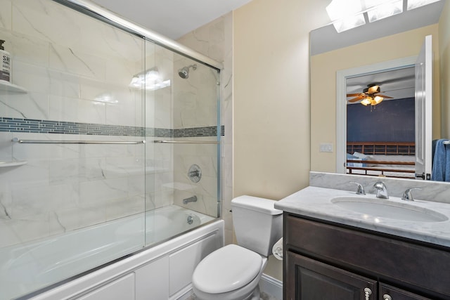 full bathroom featuring vanity, toilet, ceiling fan, and shower / bath combination with glass door