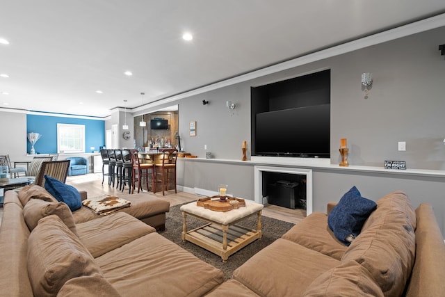 living room featuring light hardwood / wood-style flooring and ornamental molding