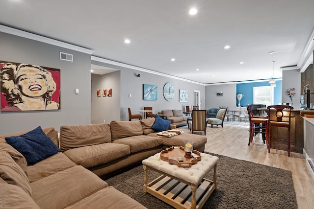 living room with light hardwood / wood-style floors and crown molding