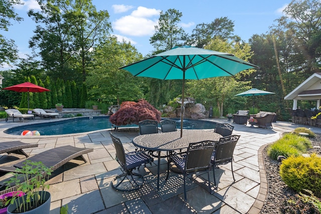 view of swimming pool featuring pool water feature and a patio