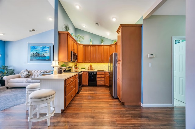 kitchen with kitchen peninsula, dark hardwood / wood-style flooring, tasteful backsplash, stainless steel appliances, and a breakfast bar area