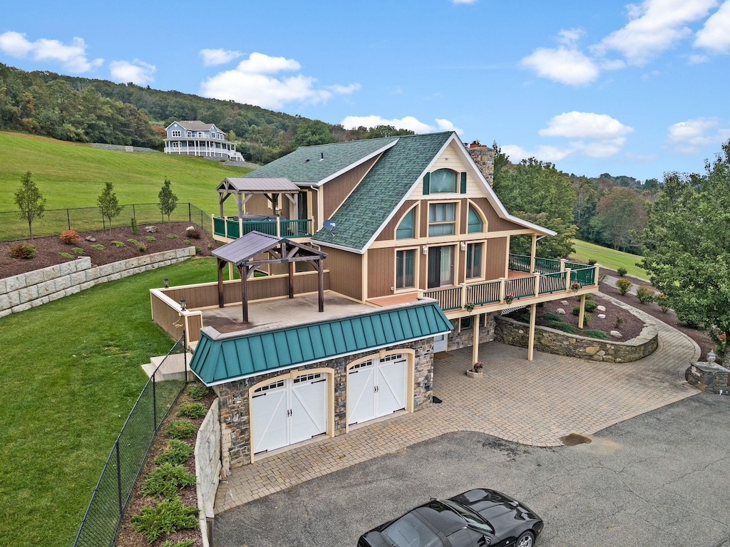 rear view of house featuring a gazebo, a yard, and a garage