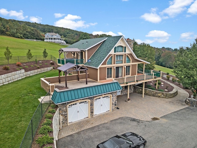 rear view of house featuring a gazebo, a yard, and a garage