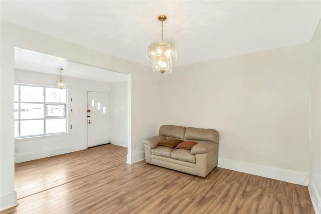 living area with hardwood / wood-style floors and an inviting chandelier