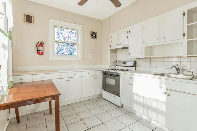 kitchen featuring sink, white cabinets, white range with gas stovetop, light tile patterned flooring, and custom exhaust hood