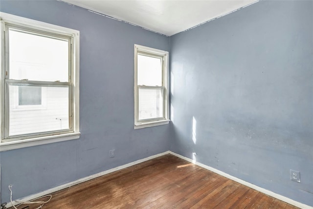 empty room with dark hardwood / wood-style flooring