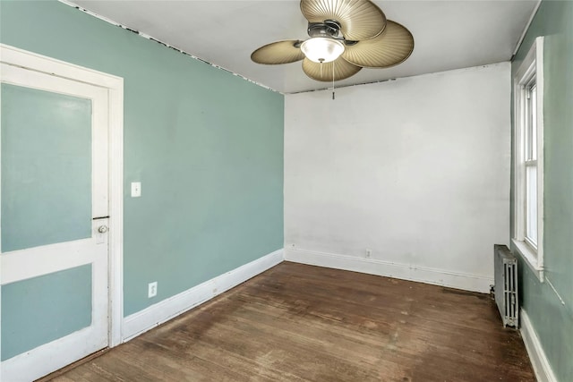 unfurnished room featuring radiator heating unit, dark hardwood / wood-style flooring, and ceiling fan