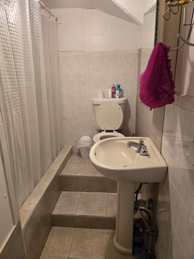 bathroom featuring curtained shower, tile patterned flooring, tile walls, and toilet