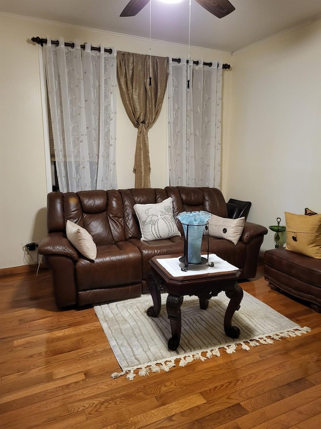 living room featuring hardwood / wood-style flooring, ceiling fan, and crown molding