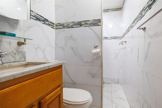 bathroom featuring vanity, toilet, and a tile shower