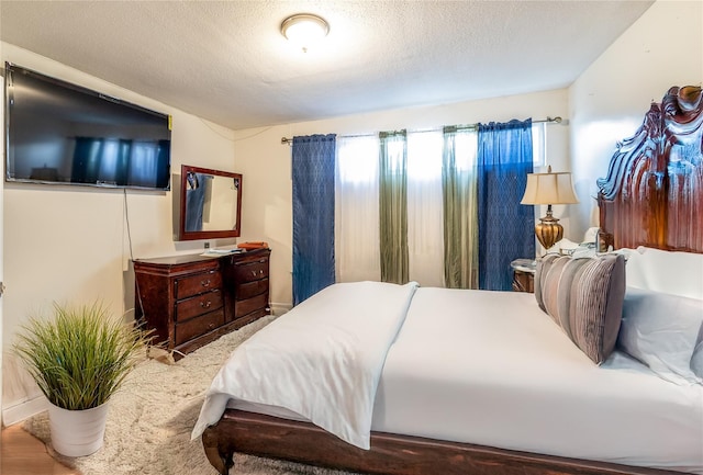 bedroom with wood-type flooring and a textured ceiling