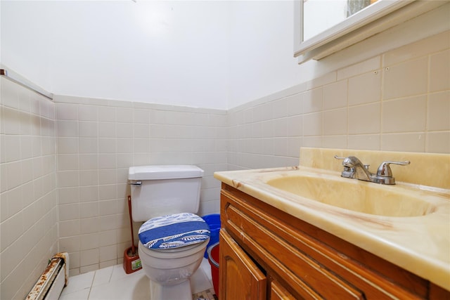 bathroom featuring vanity, a baseboard radiator, tile walls, tile patterned flooring, and toilet